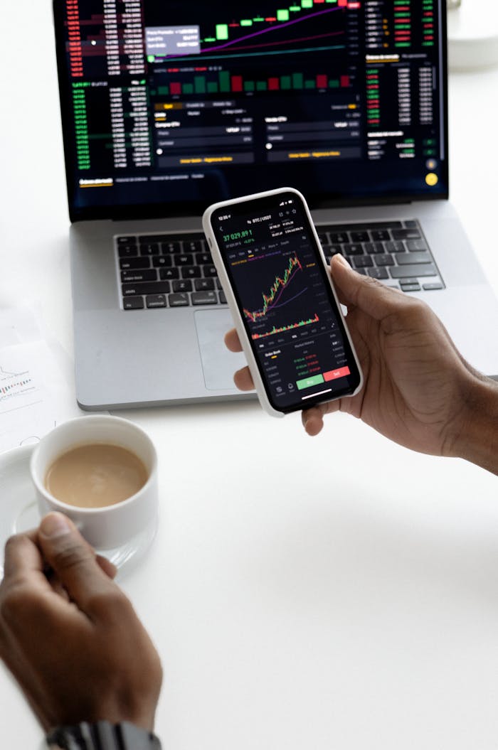 Crafting Captivating Headlines: Your awesome post title goes here Person analyzing stock market trends on smartphone with laptop background